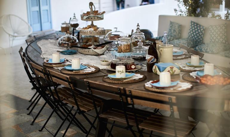 Table de petit déjeuner dressée avec assiettes et tasses.