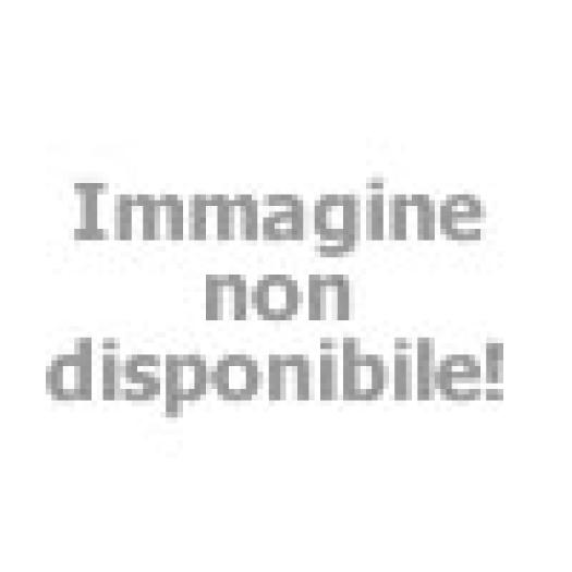 Coppia a colazione all'aperto in un hotel boutique, atmosfera rilassata e conviviale.